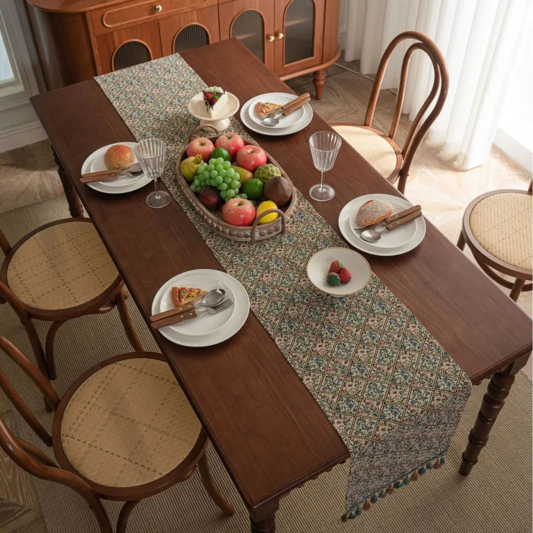 Rhyme Nordic striped jacquard table runner with tassel fringe in dark blue on a wooden table.