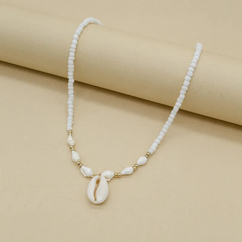 White necklace with a natural shell and mother of pearl pendant on a regular chain.