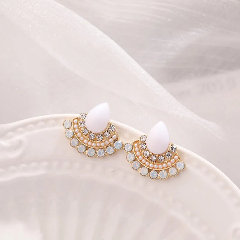 Close-up of women's retro silver fan-shaped rhinestone earrings with needle posts.