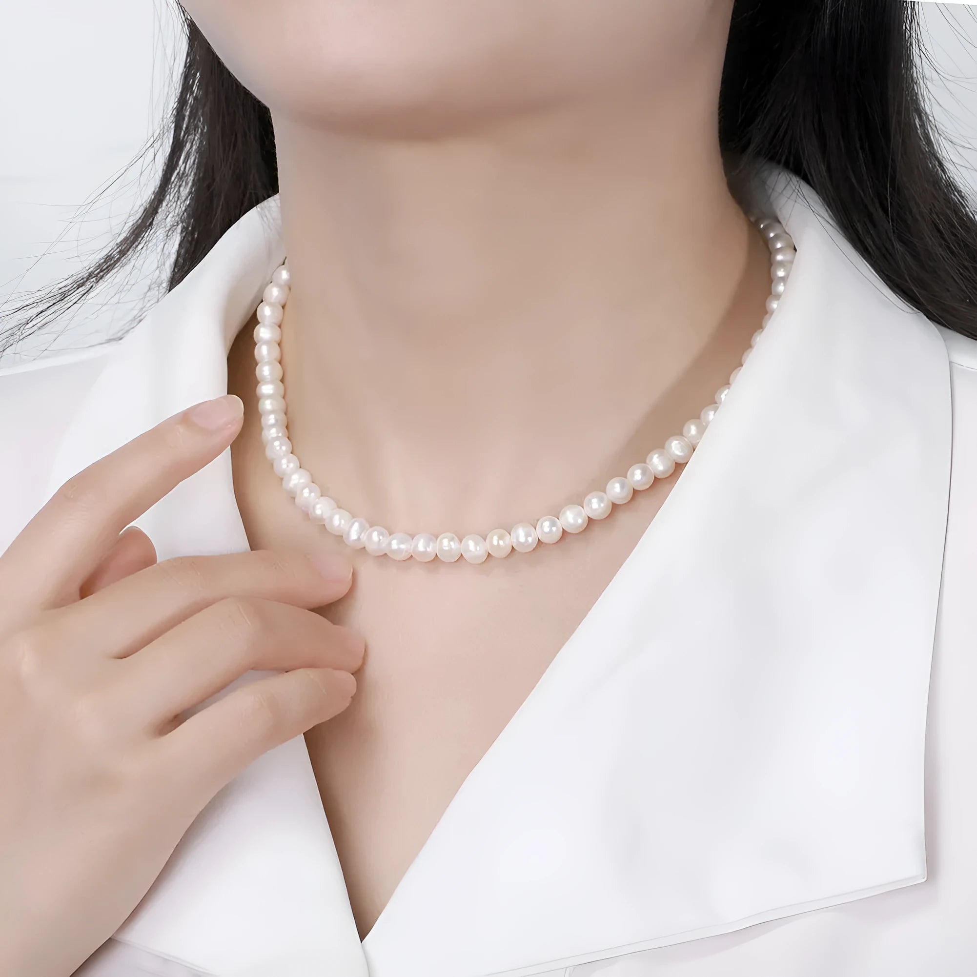 Close-up of a women's adjustable silver necklace with a natural freshwater pearl centrepiece.
