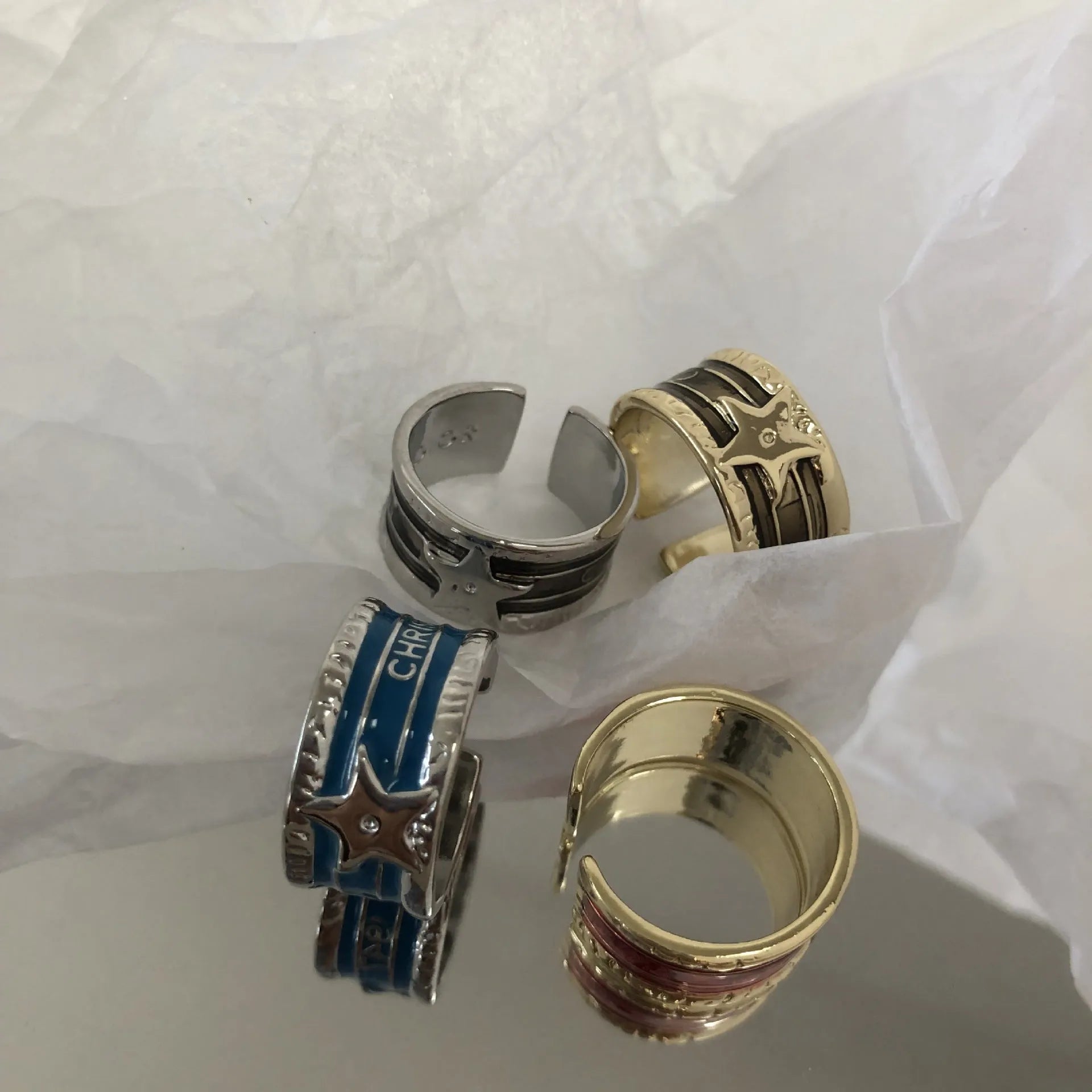 Adjustable geometric copper ring with a distressed finish in black, red, blue, and two-tone colour options.