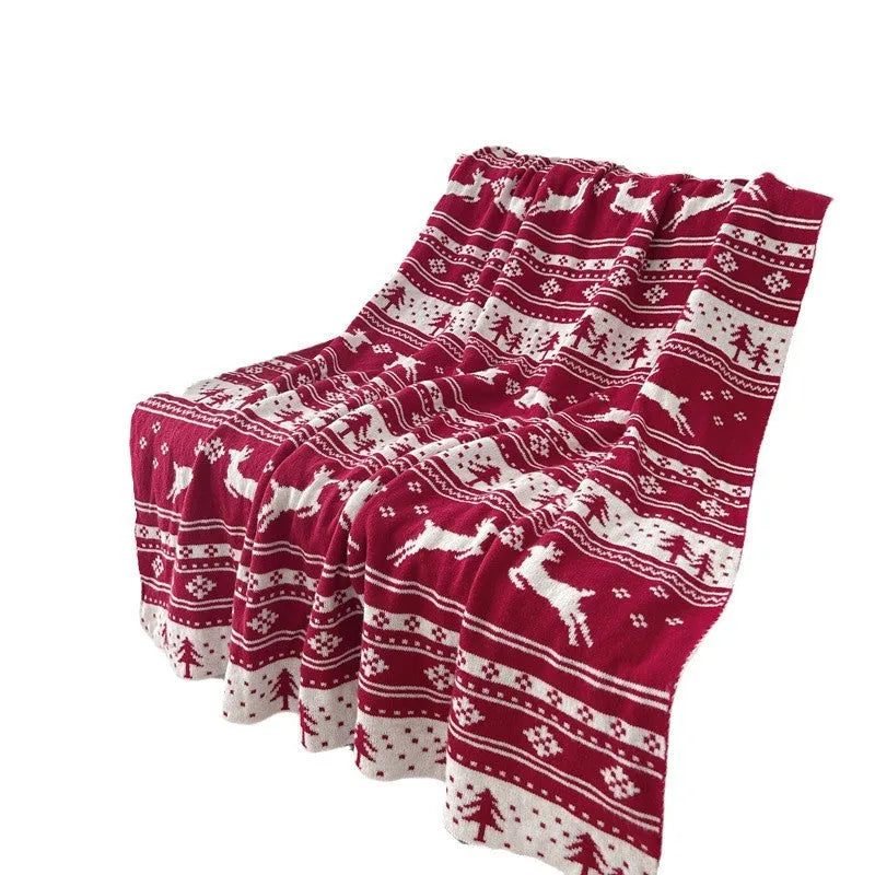 Personalised acrylic Christmas blanket with reindeer pattern draped over a grey sofa