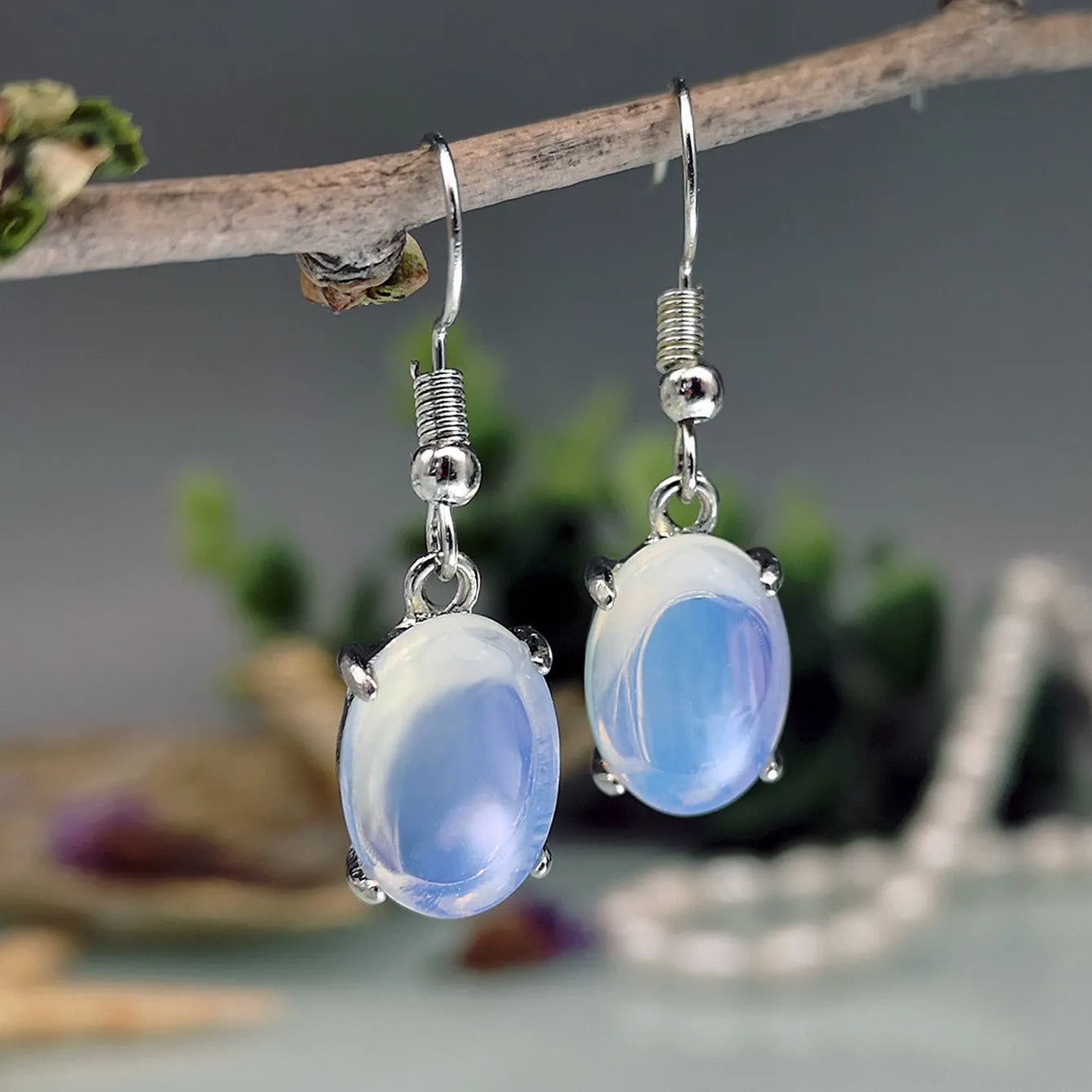 Moonlight white opal earrings with retro drop shape and cross charm detail