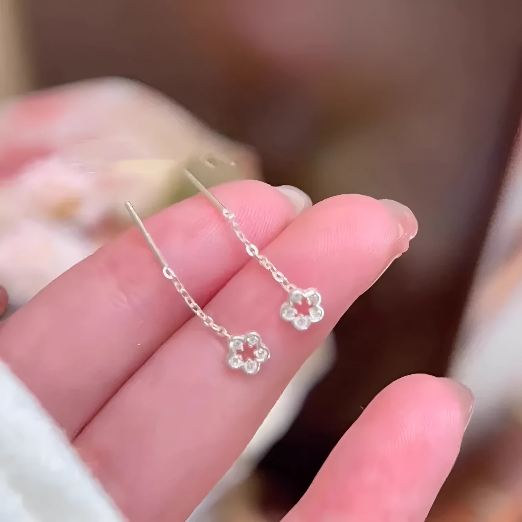 Silver hollow flower hanging earrings with natural petal design on earwire backing