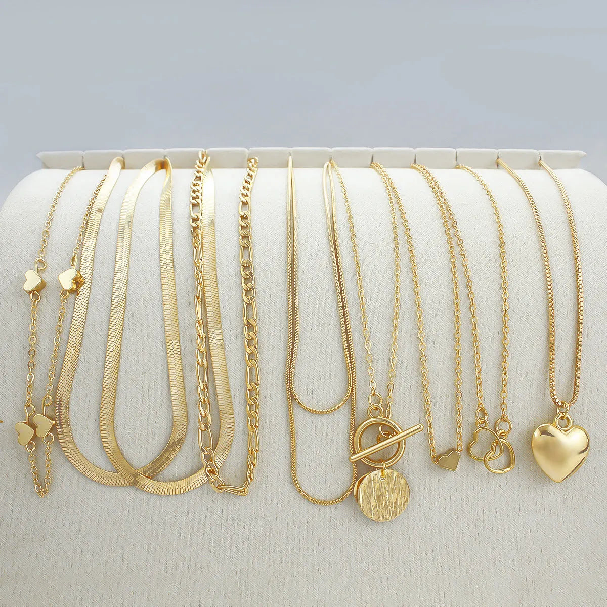 Gold tone women's necklace set with 10 ornamental pieces on snake bone chain