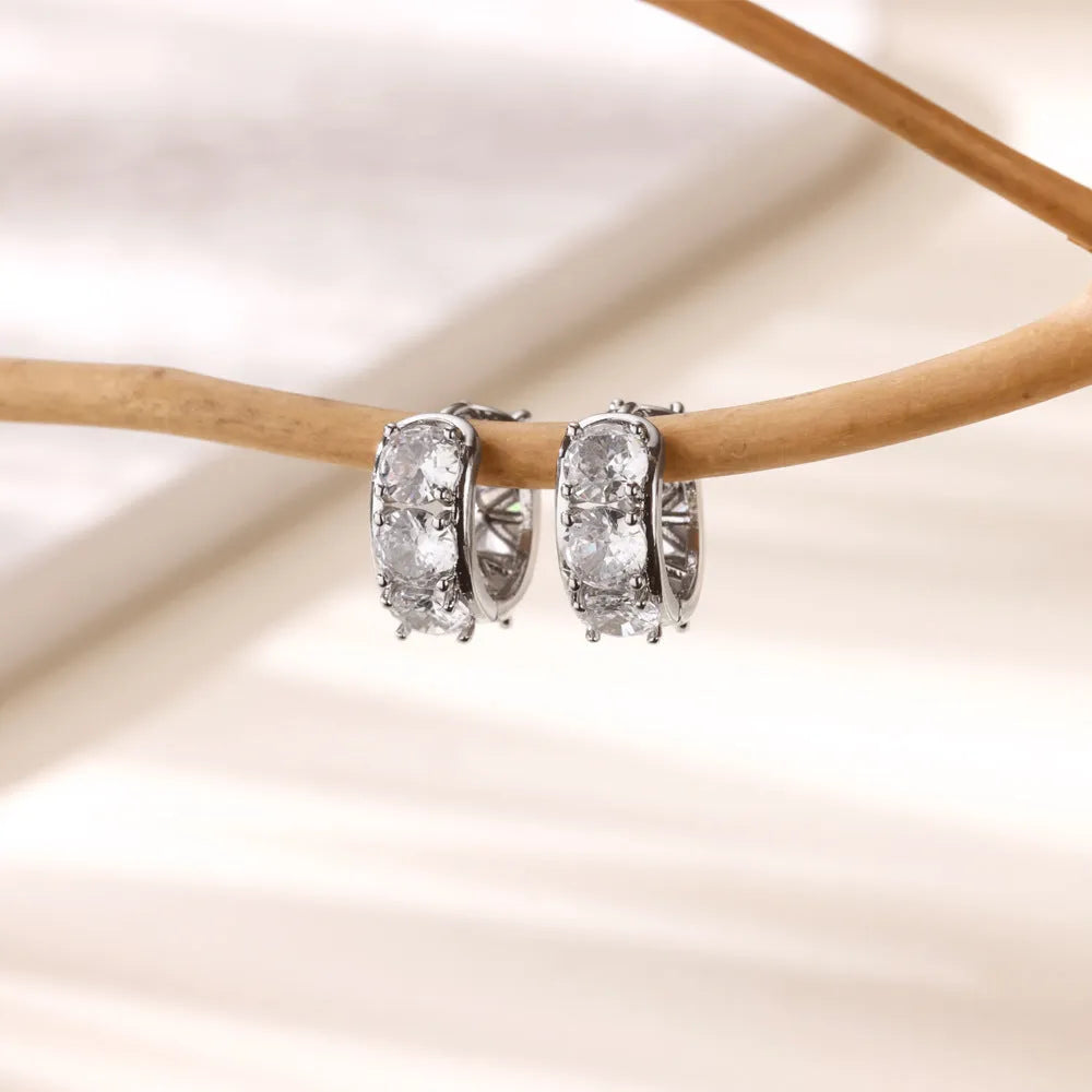Close-up of a pair of silver U-shaped clip-on earrings for women with inlaid sparkling zircon stones.