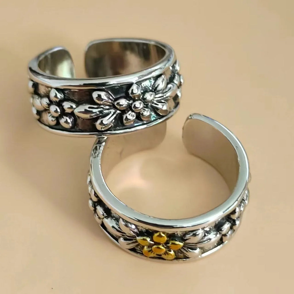 Vintage antique silver gold flower open ring with camellia design on a plain background