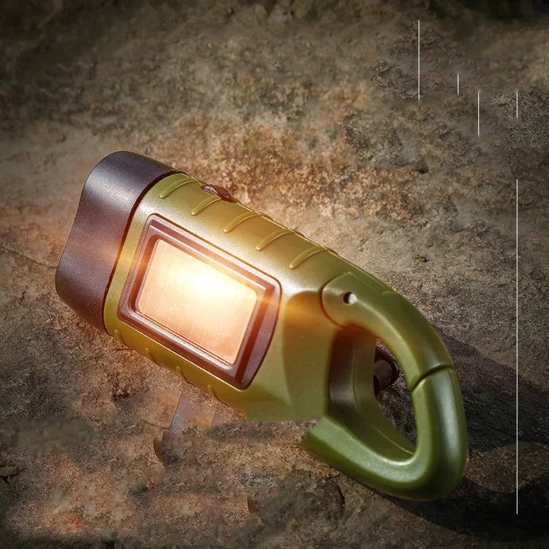 Hand-crank and solar powered olive green LED flashlight with USB charging port.