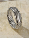 Gold elastic titanium steel bracelet with a wide vertical stripe ring pattern on a wrist.