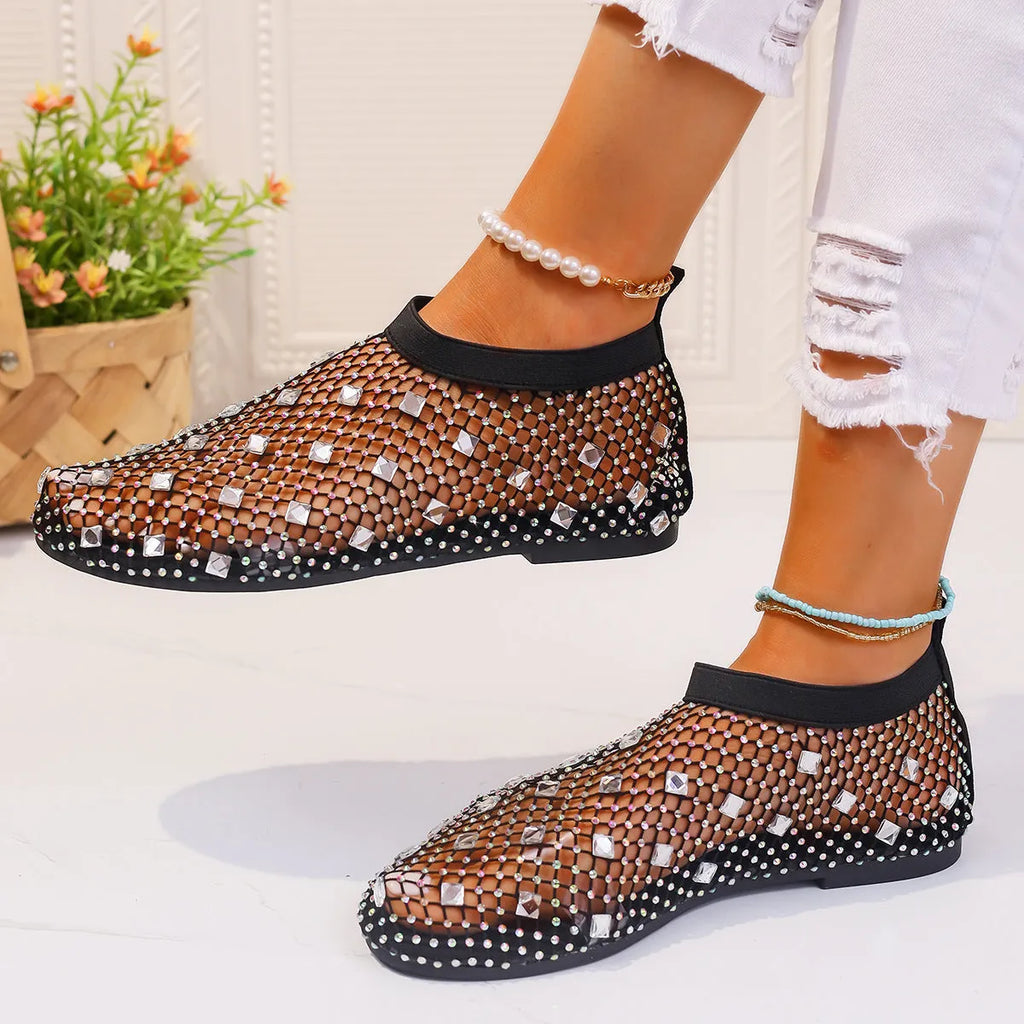 Colourful rhinestone detail on women's white mesh flat sandals with a rubber sole.