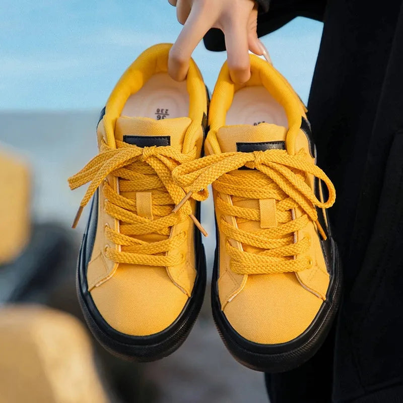 Women's low-top lace-up board shoes in synthetic leather with a vulcanised rubber sole, shown in a two-tone colour option.