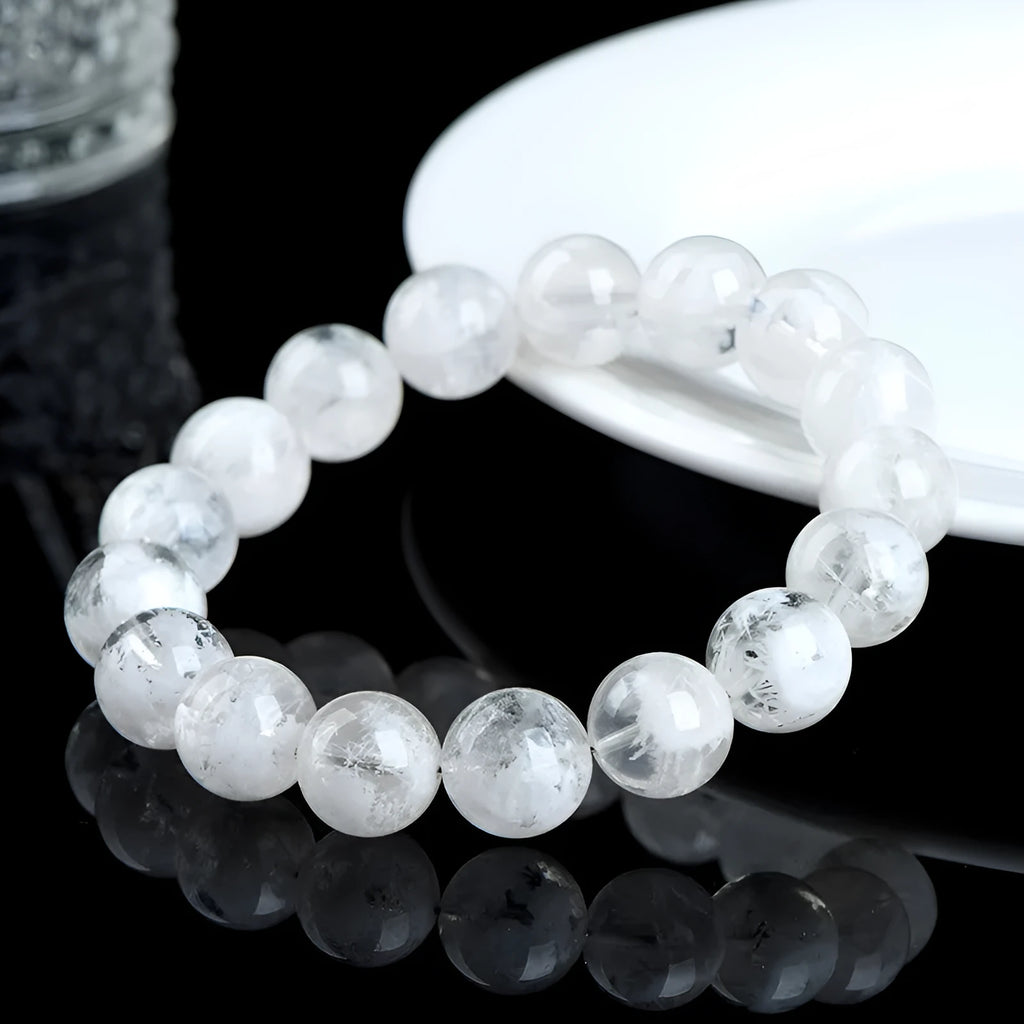 Women's natural blizzard snowflake round bead crystal bracelet with geometric design on a wrist.