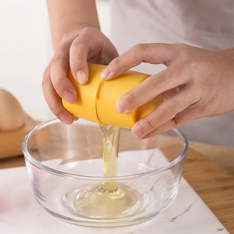 Egg shell opener and beater kitchen tool in pink, yellow, or orange colour on a kitchen counter.