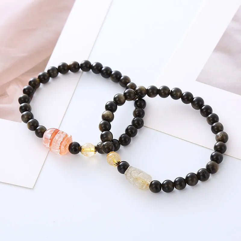 Handcrafted natural obsidian Pi Xiu bracelet with gold and red design on wrist