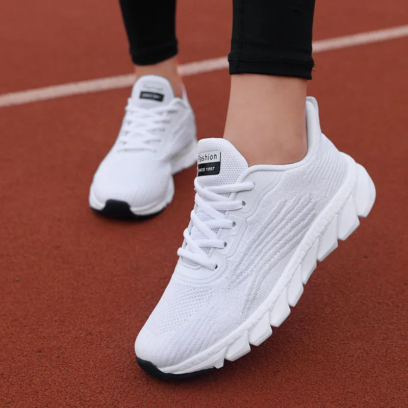 Black and white platform running sneakers with round toe and cross strap details