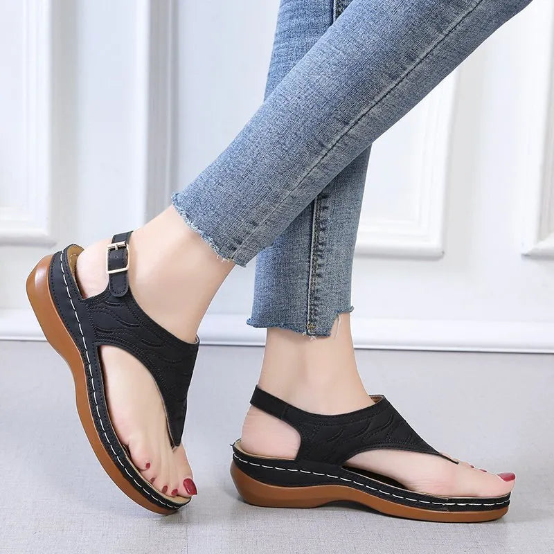 Women's casual wedge heel flip flop sandal in black with adjustable buckle strap.
