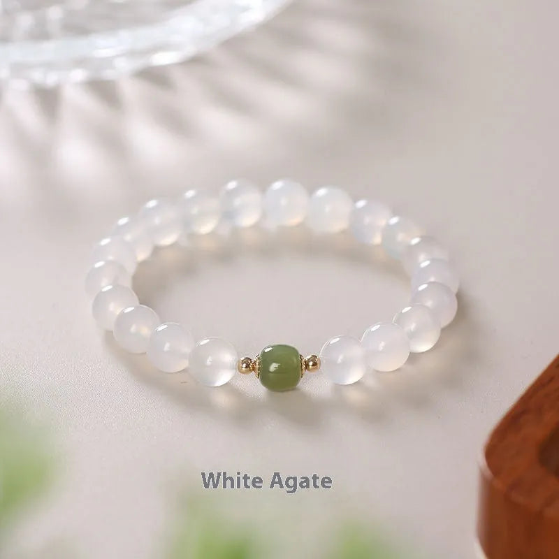 Handmade white agate and crystal bracelet with cinnabar inlay, showing text design on beads