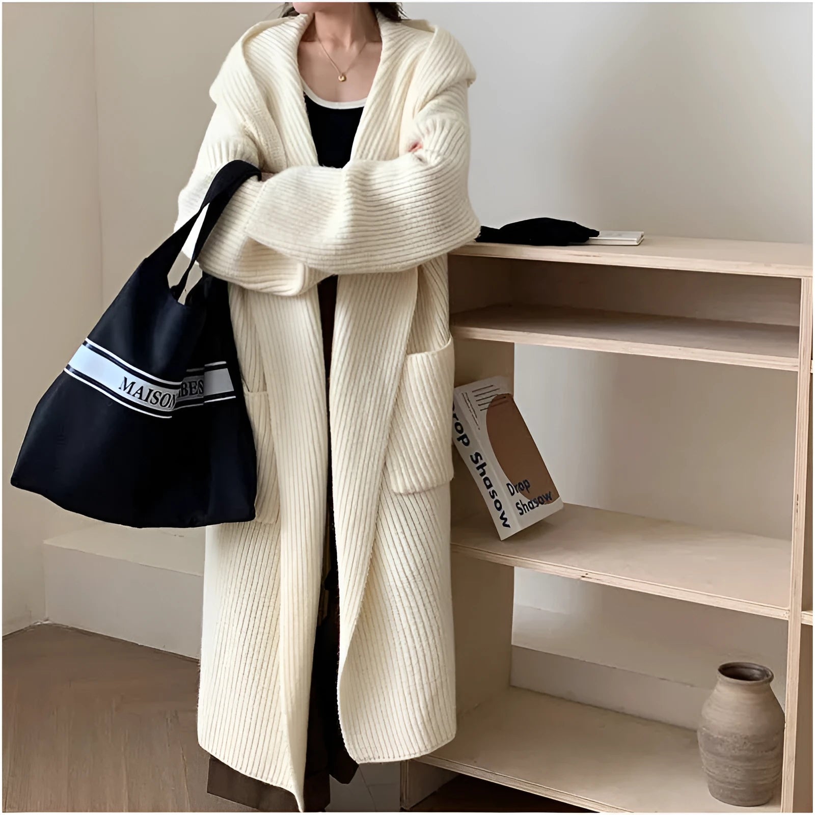Woman wearing a long loose hooded cardigan coat in acrylic fabric, open as a cardigan.
