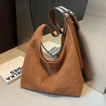 Women's suede bucket bag in black with stitching detail, single shoulder strap, and outer sandwich pocket