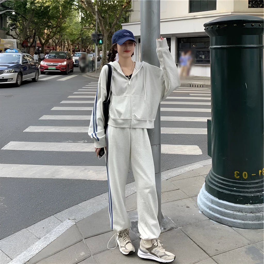Women's two-piece striped polyester tracksuit set, light gray, top and trousers on plain background