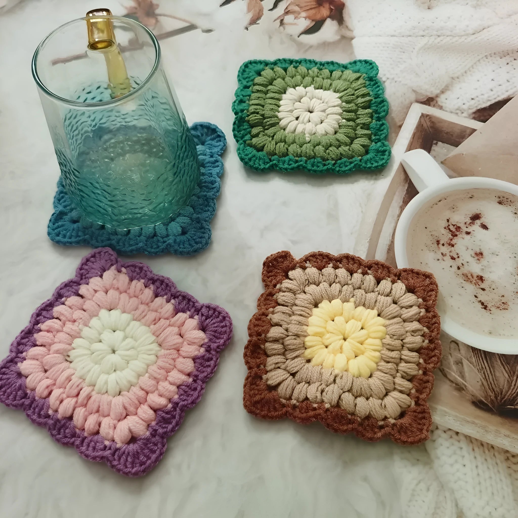Hand-crocheted wool coaster with lattice pattern in Dream Purple colour on a wooden table.