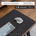 Oversized black and gray felt desk mat with cork base on a wooden desk