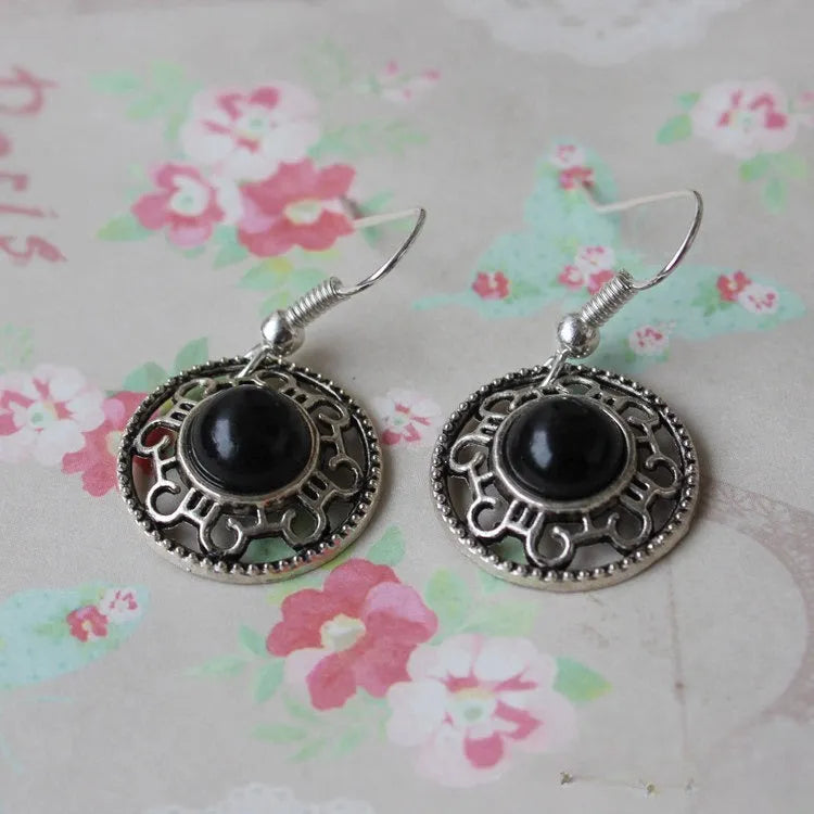 Handmade Miao silver geometric flower disk earrings with turquoise and auspicious cloud patterns in red, blue, black.