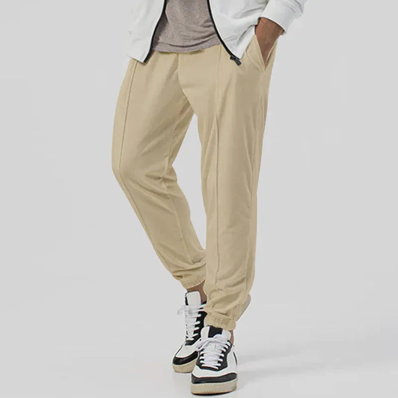 Man wearing grey straight-leg casual track sweatpants with an elasticated waist and micro-elastic fabric.