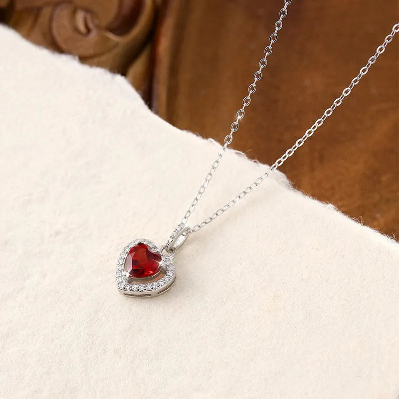 Women's sterling silver heart necklace with a natural gemstone on an adjustable cross chain.