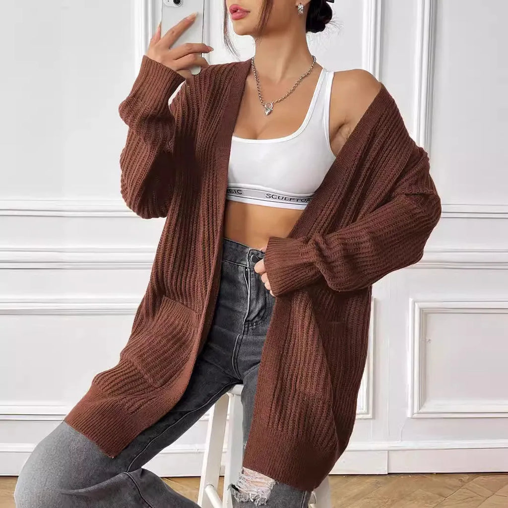 A dark green loose-fit sweater cardigan with two front pockets and long sleeves.