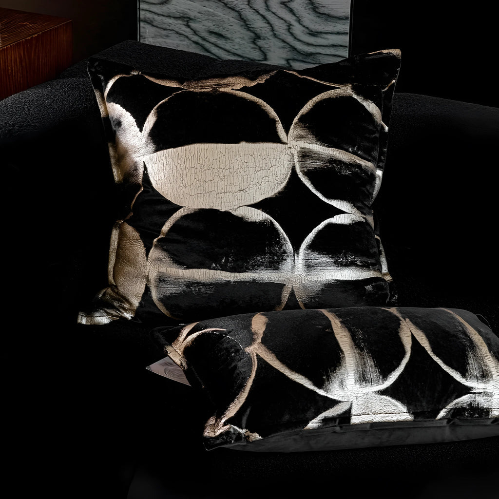Black and gold abstract full moon pattern flannel cushion on a grey sofa