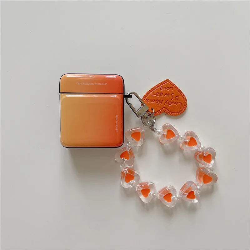 Soft TPU protective sleeve for AirPods 1/2 and Pro/3 in gradient pink, orange, or blue with love pendant.