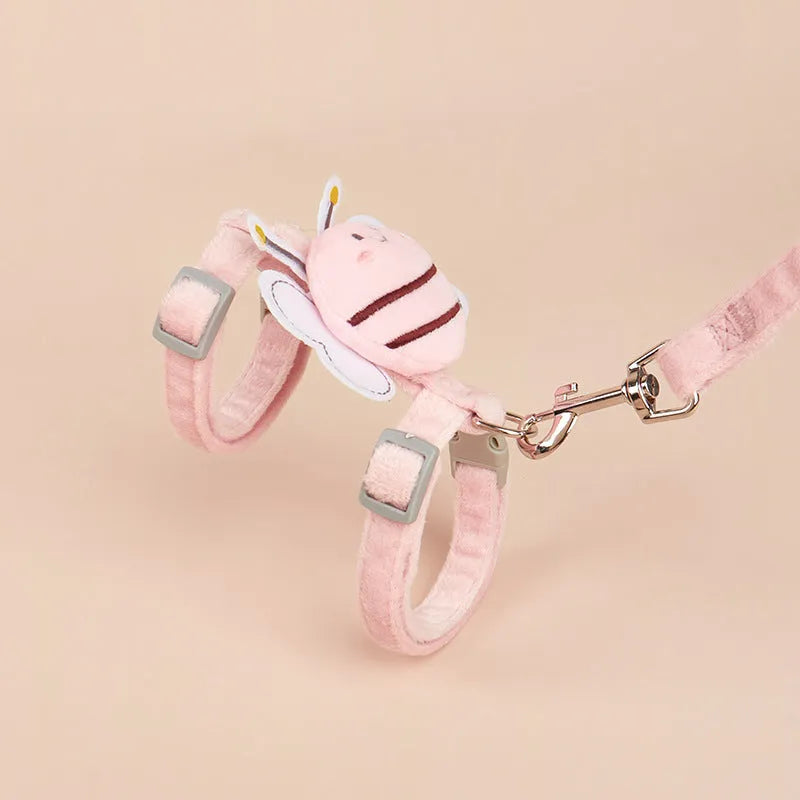 Pink, yellow, and blue bee-shaped adjustable cat leash with strap and hand rope on grass.