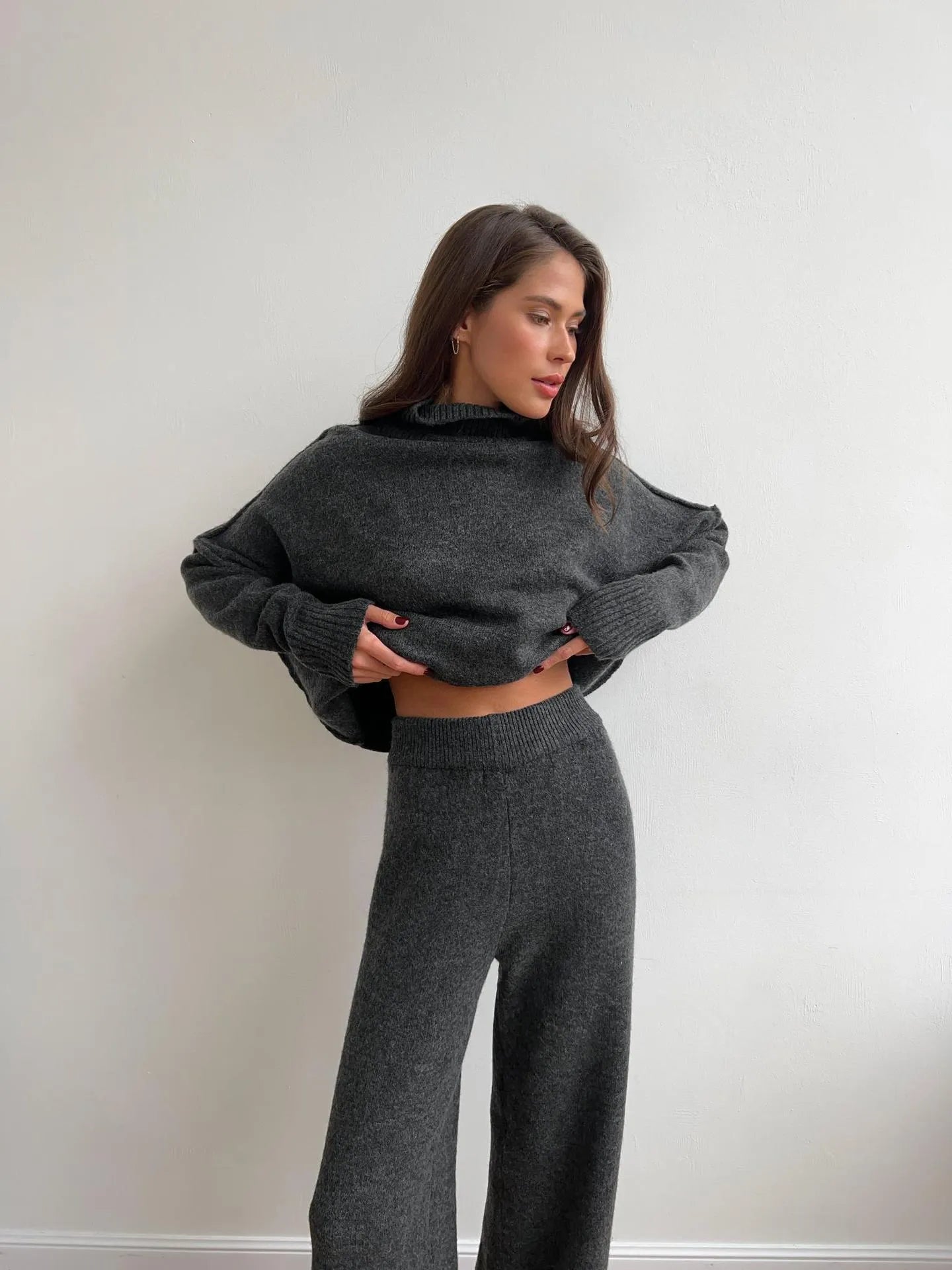 Women's dark grey acrylic knit co-ord set with side-slit sweater and matching trousers laid flat.