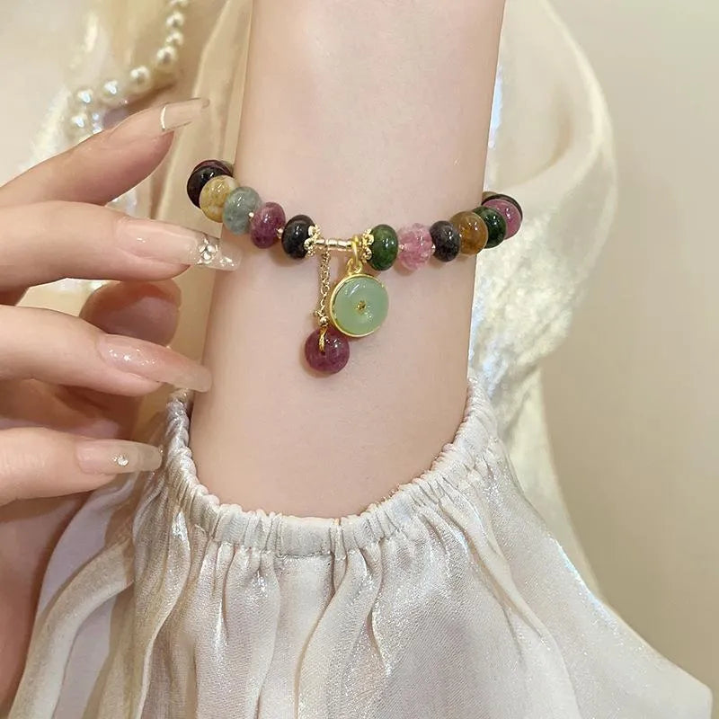 Close-up of a colourful tourmaline rabbit pendant bracelet with natural stone round beads.