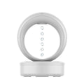 White round anti-gravity humidifier showing optical illusion of levitating water droplets on a desk.