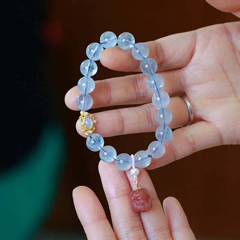 DIY adjustable aquamarine bead bracelet with pearl accents and a Chinese style fox Fengjiu charm.