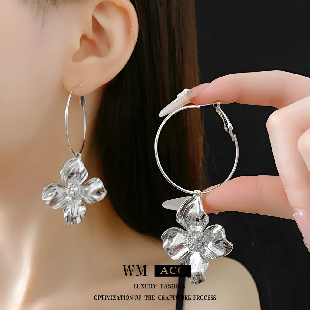 A pair of vintage-style geometric flower earrings with silver needle detailing, shown in gold and silver colour options.