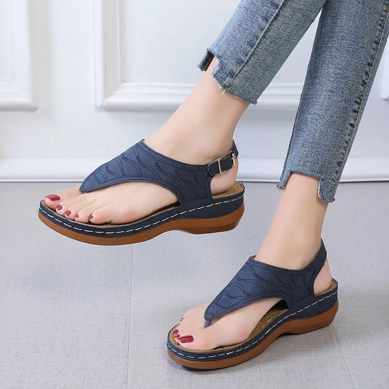 Women's casual wedge heel flip flop sandal in black with adjustable buckle strap.