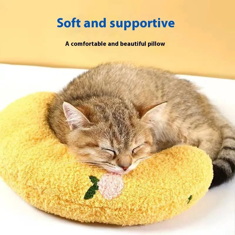 Blue U-shaped question mark cat pillow on a carpet, showing its contoured neck support design.