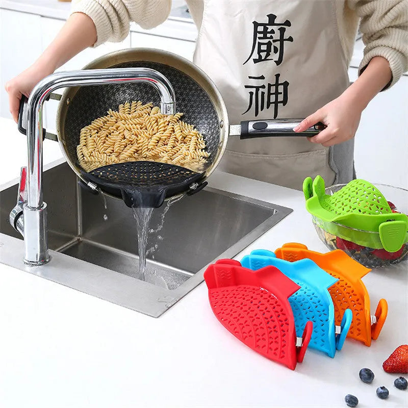 Green silicone pot rim drainer with stainless steel frame on a kitchen counter.