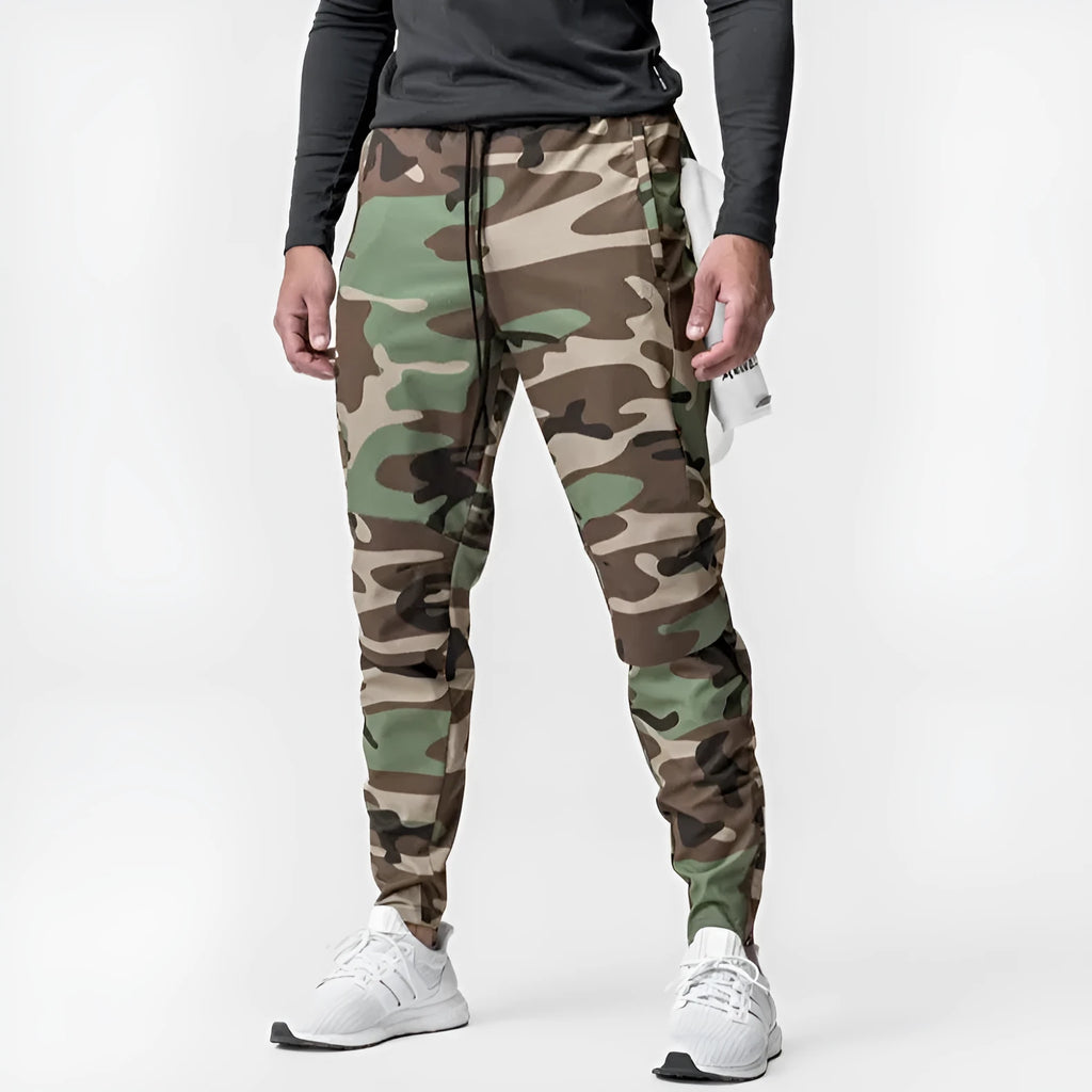 Men's grey loose-fit fitness trousers with ankle ties, made from quick-drying polyester fabric.