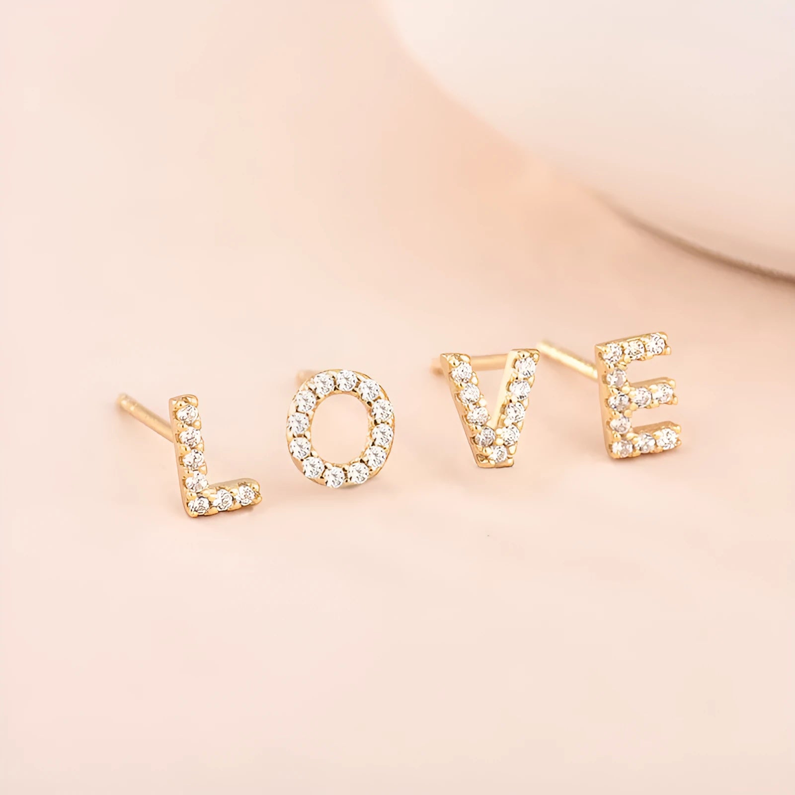 Gold plated brass earring in the shape of the letter A, set with a sparkling zircon stone.