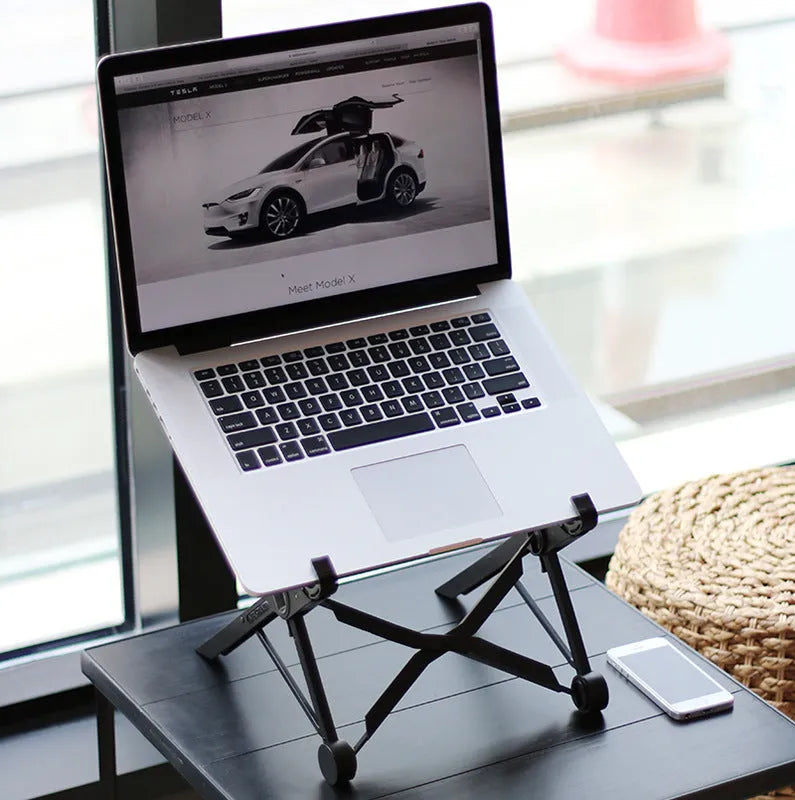 Sagacious black foldable laptop stand made of enhanced nylon, shown open and next to its portable carry bag.