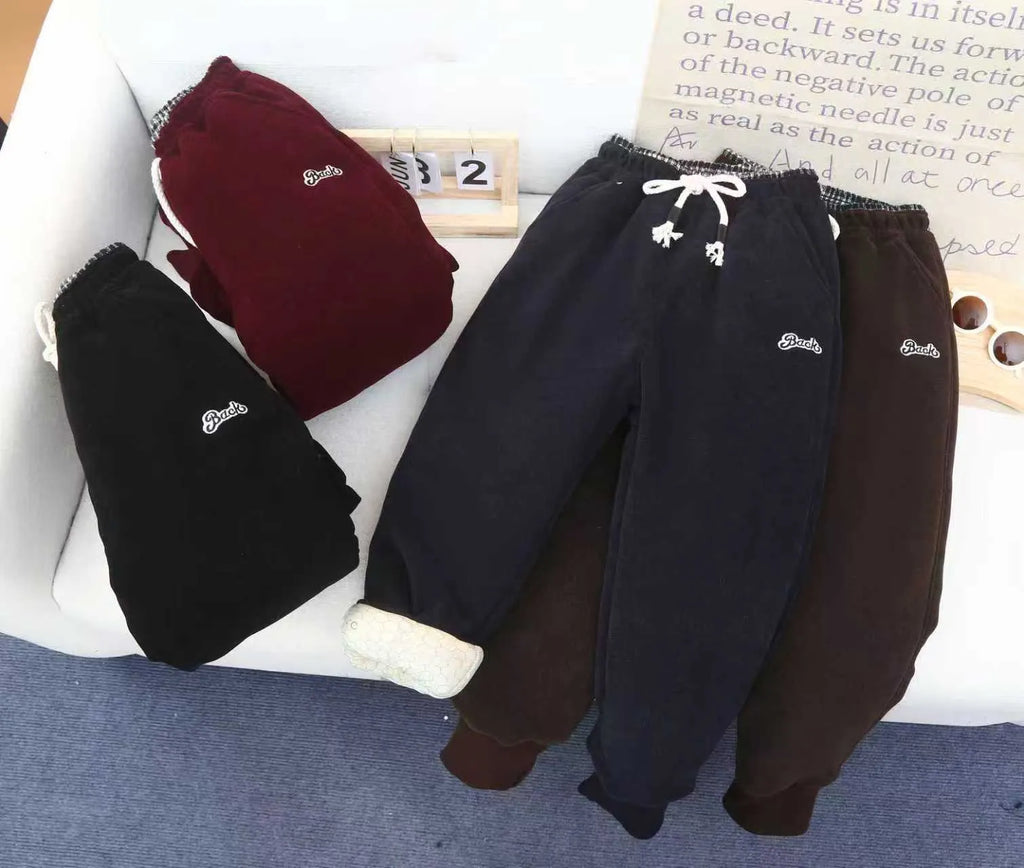 Forest Star children's trousers in black, side view showing drawstring waist and tapered legs with tight cuffs