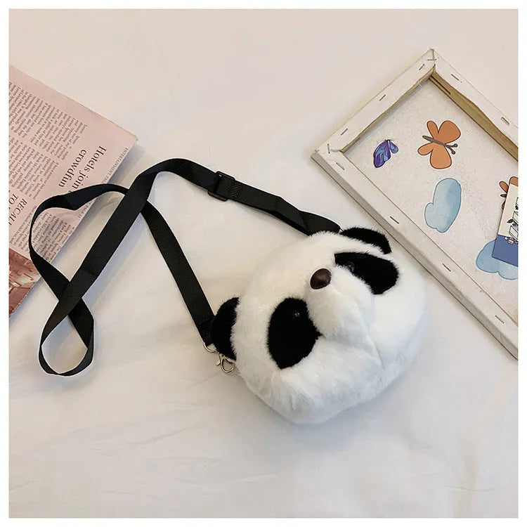 Soft plush panda head design crossbody bag in cylindrical shape on a white background.
