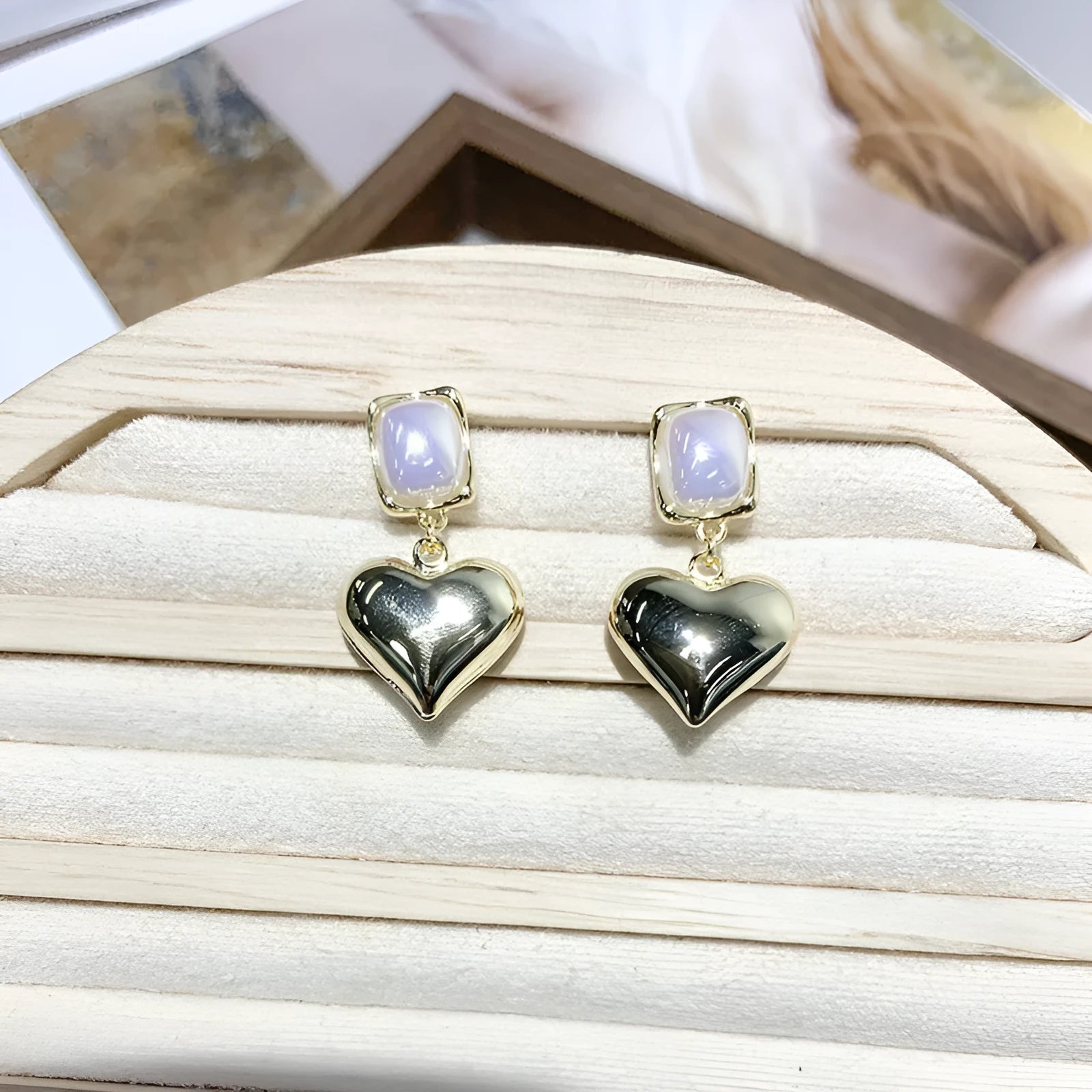 Small gold heart stud earrings with hypoallergenic metal finish on white background