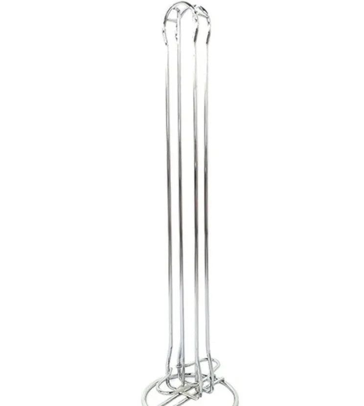 Black wrought iron coffee capsule storage rack holding pods on shelves.