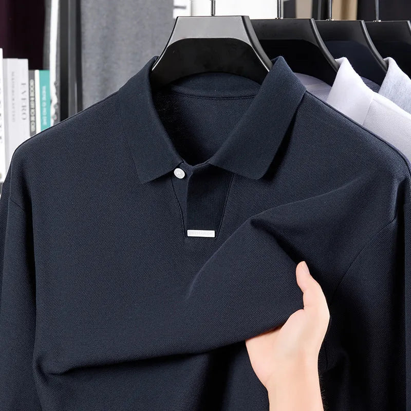 Man wearing a loose fit gray cotton polo shirt with an asymmetric lapel collar and long sleeves.
