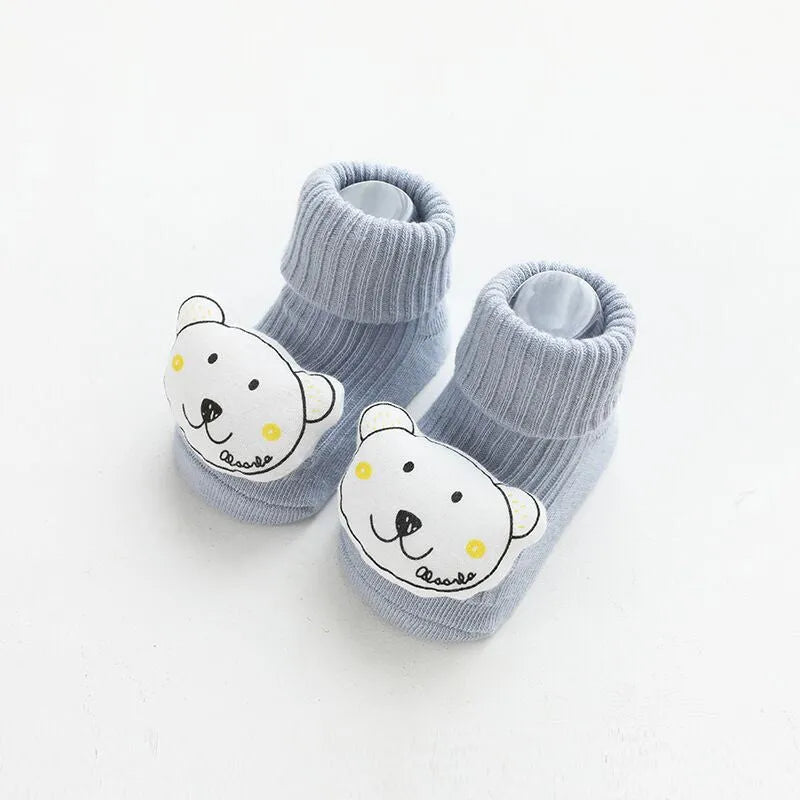 Pair of light grey baby socks with white non-slip silicone grip dots on the soles.